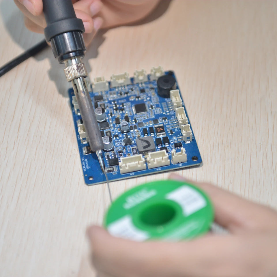 A technician soldering an X1 control board during route-planning development.